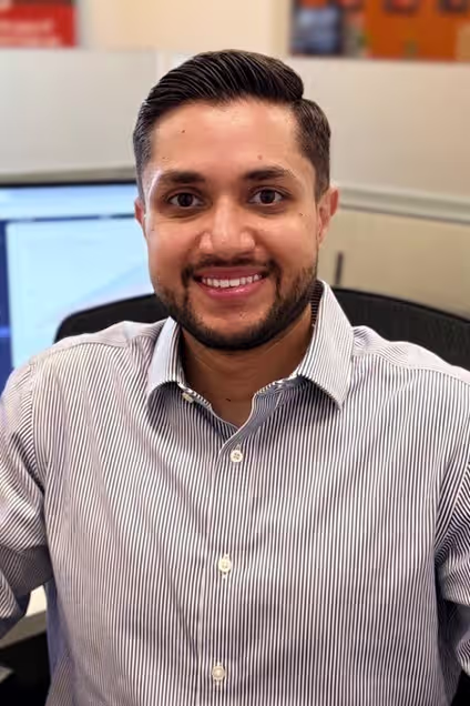 Kelser Corporation IT support team member smiling at office workstation in Glastonbury CT