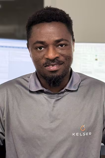 Kelser Corporation IT support team member smiling in office wearing branded Kelser shirt
