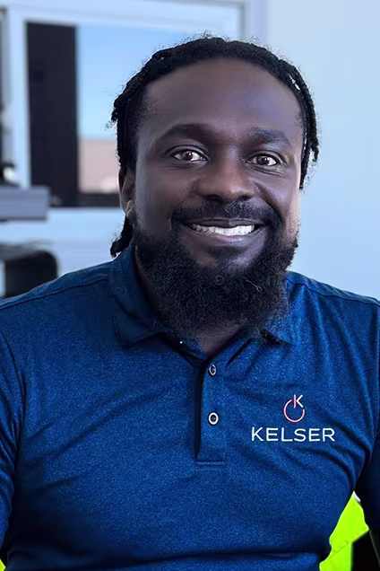 Kelser Corporation IT support team member smiling in branded blue polo shirt