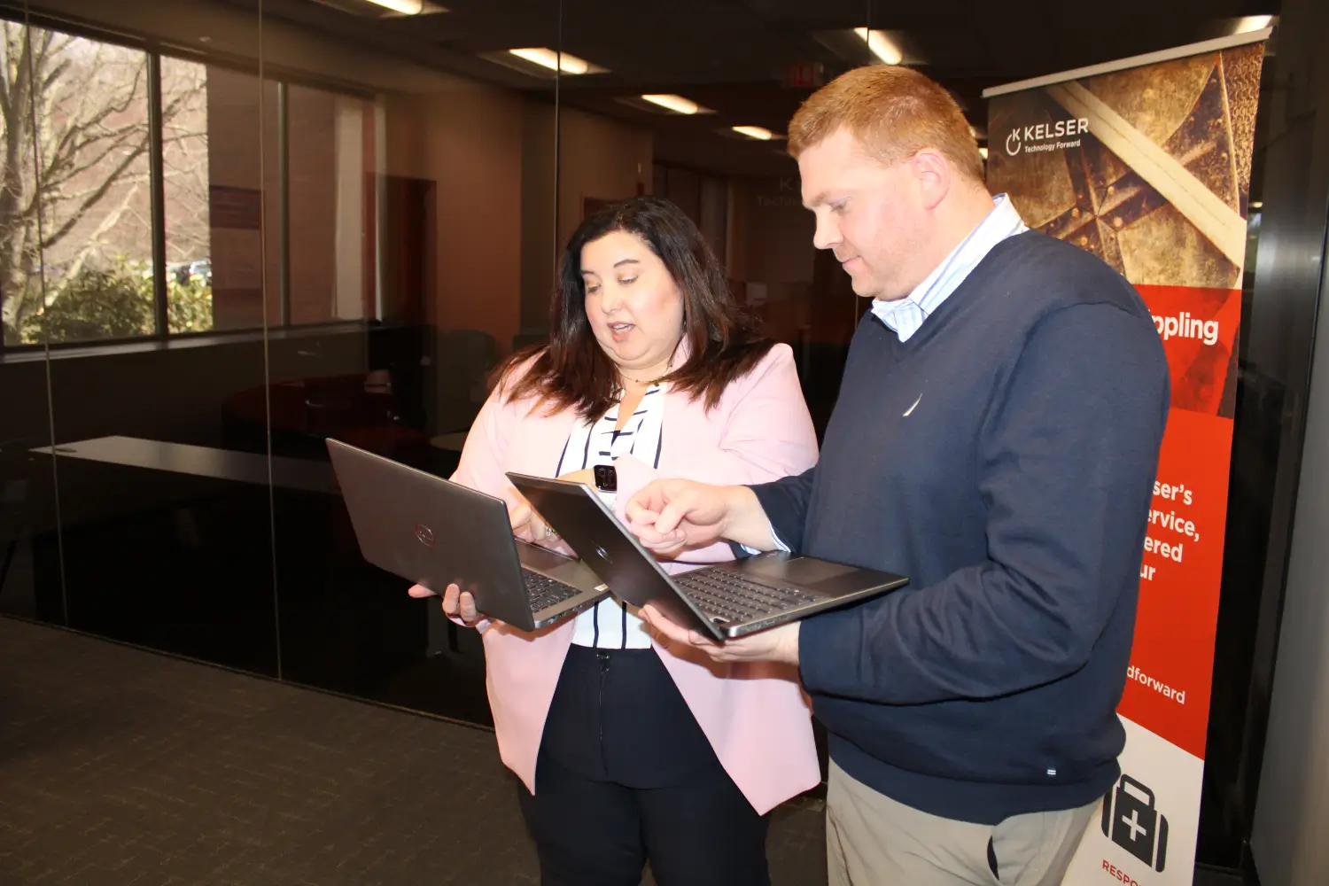Kelser IT consultants reviewing managed services solutions on laptops in a modern Connecticut office