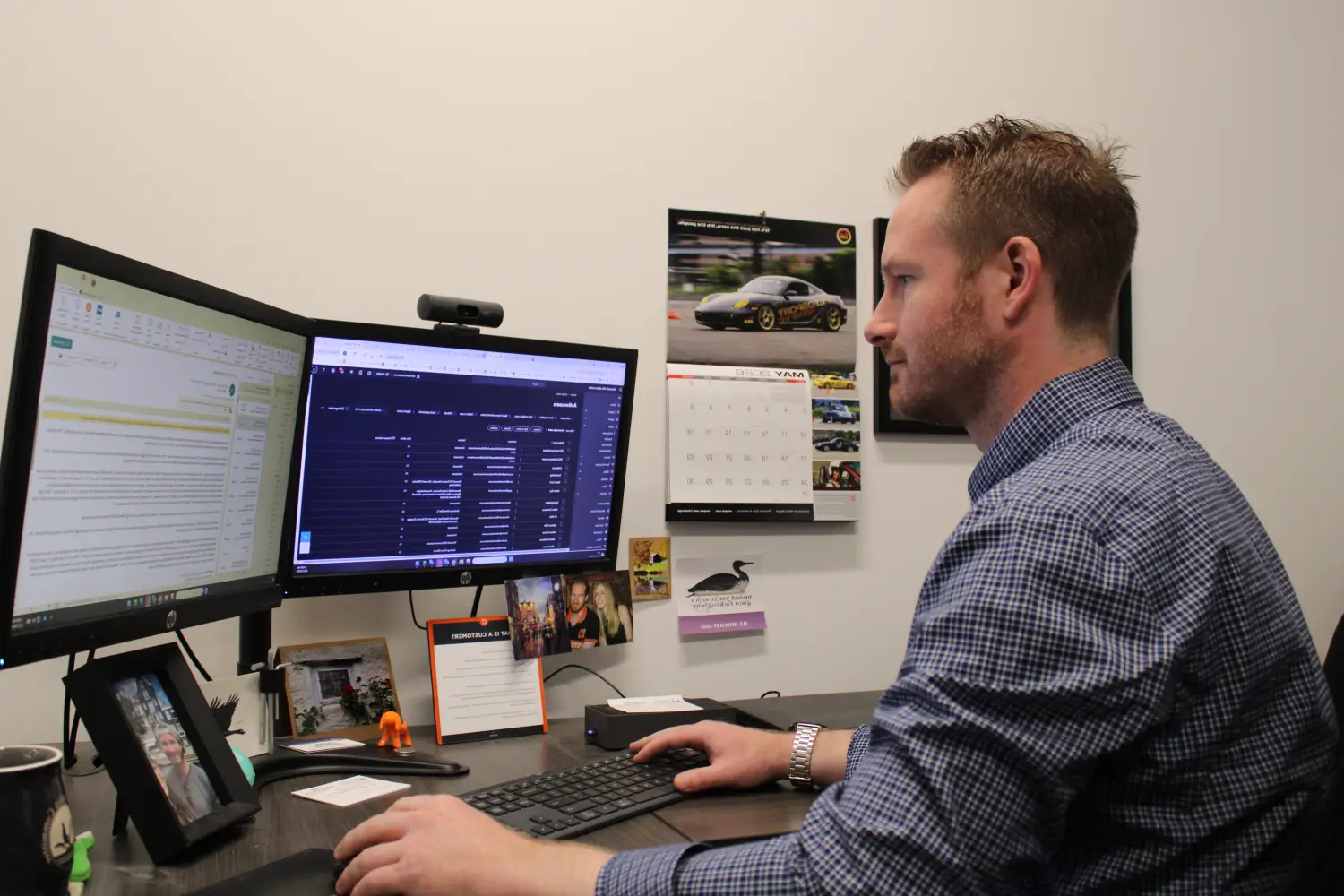 IT support technician working at dual monitor workstation managing network and IT systems in office