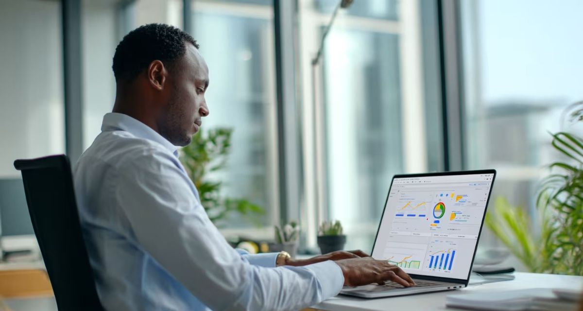 Business professional reviewing IT analytics dashboard on laptop in modern office environment