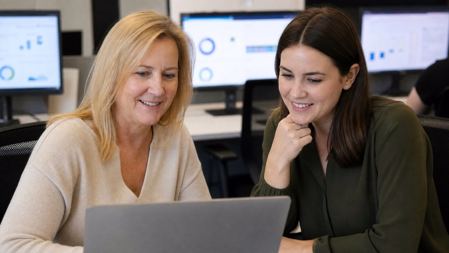 Women review phishing simulation report on laptop 57 chars