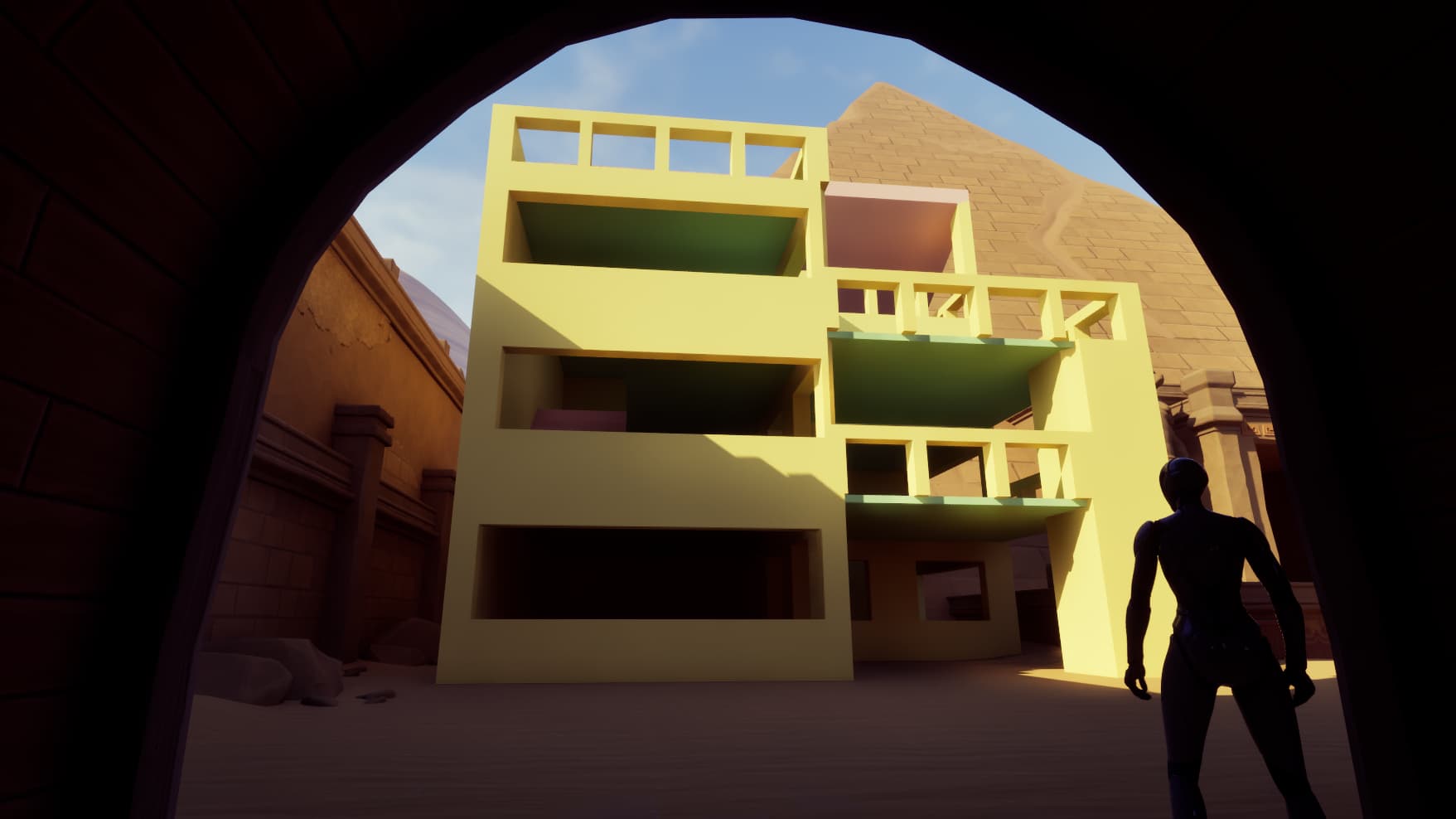 Silhouetted figure stands in archway facing blocky yellow building with balconies under blue sky.