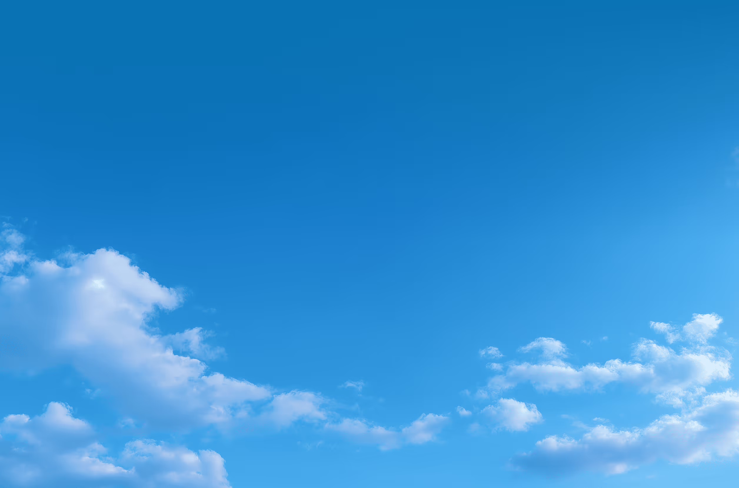 Blue sky with scattered white fluffy clouds.