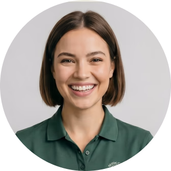 Smiling woman with short brown hair wearing a dark green polo shirt against a gray circular background