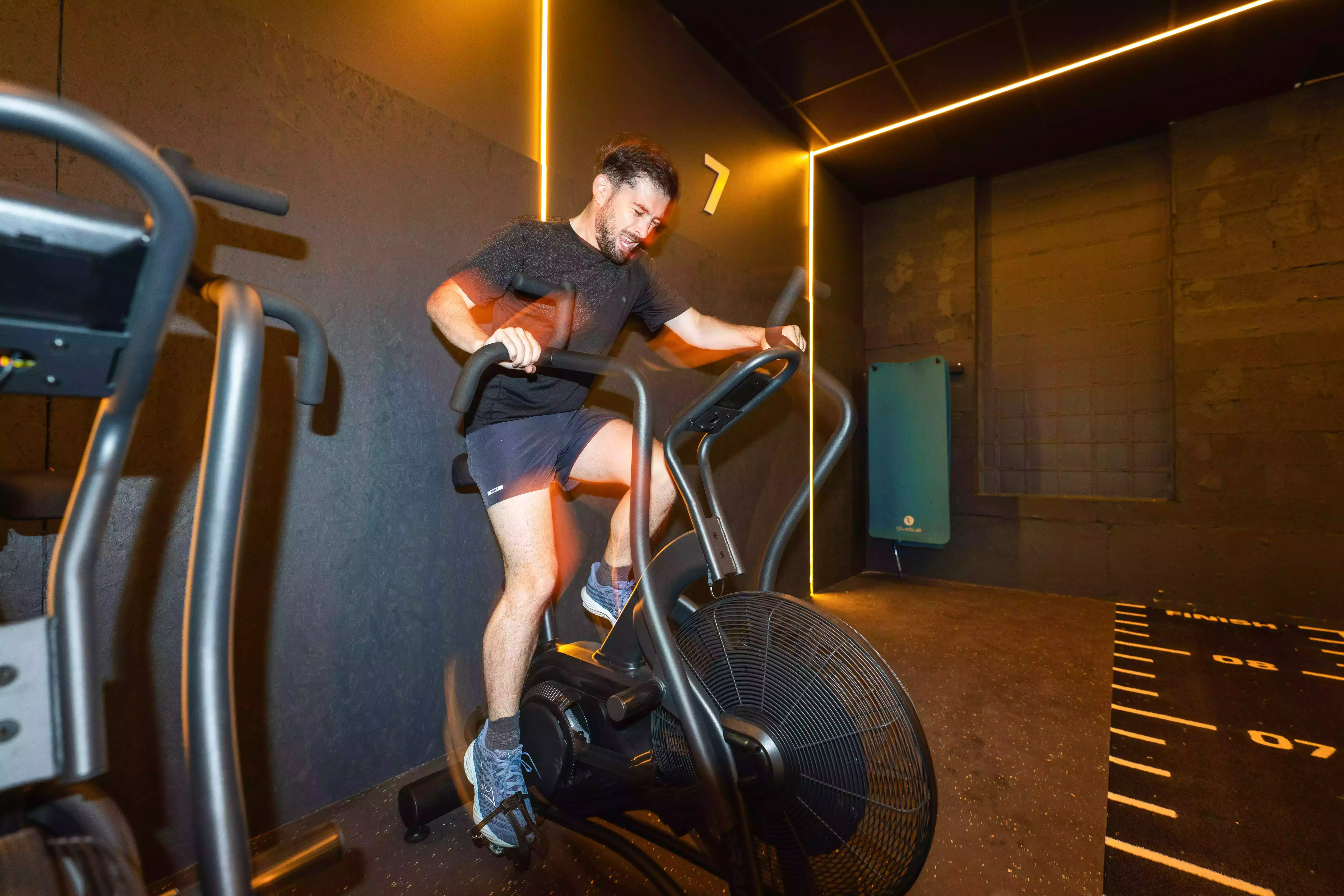 Personne utilisant vélo elliptique en salle de sport Keepcool pour séance cardio.