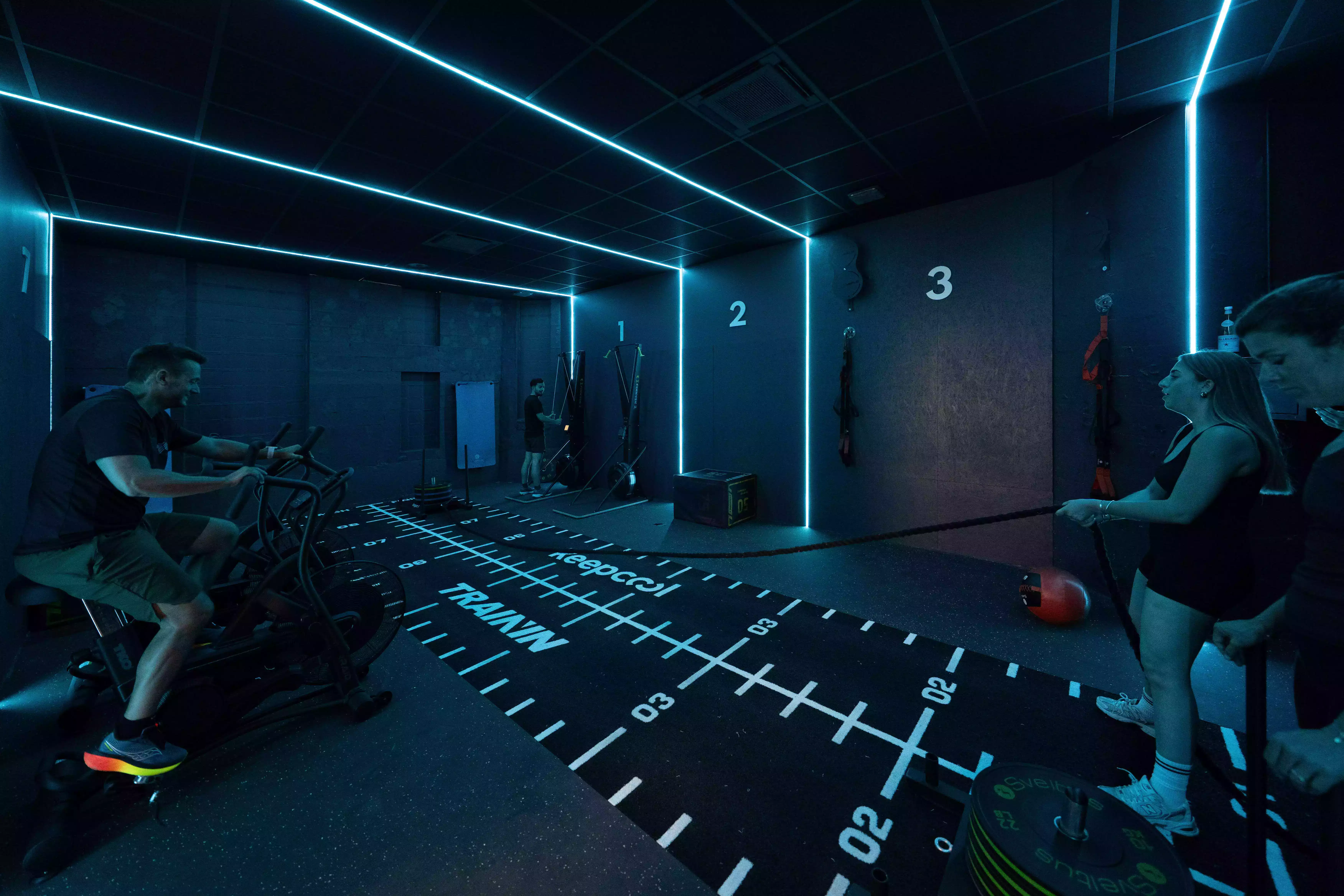 Salle de sport Keepcool équipée machines cardio et tapis de course lumineux avec mesures au sol.