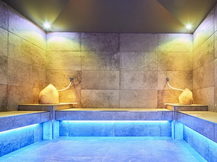 Neue Post modern lit sauna room with blue accents at the Mayrhofen hotel.