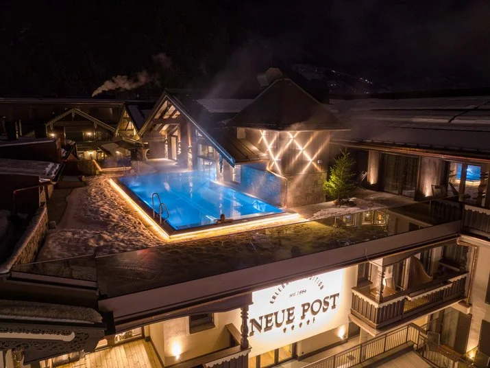 Neue Post snowy pool night view at the central Mayrhofen four-star hotel.