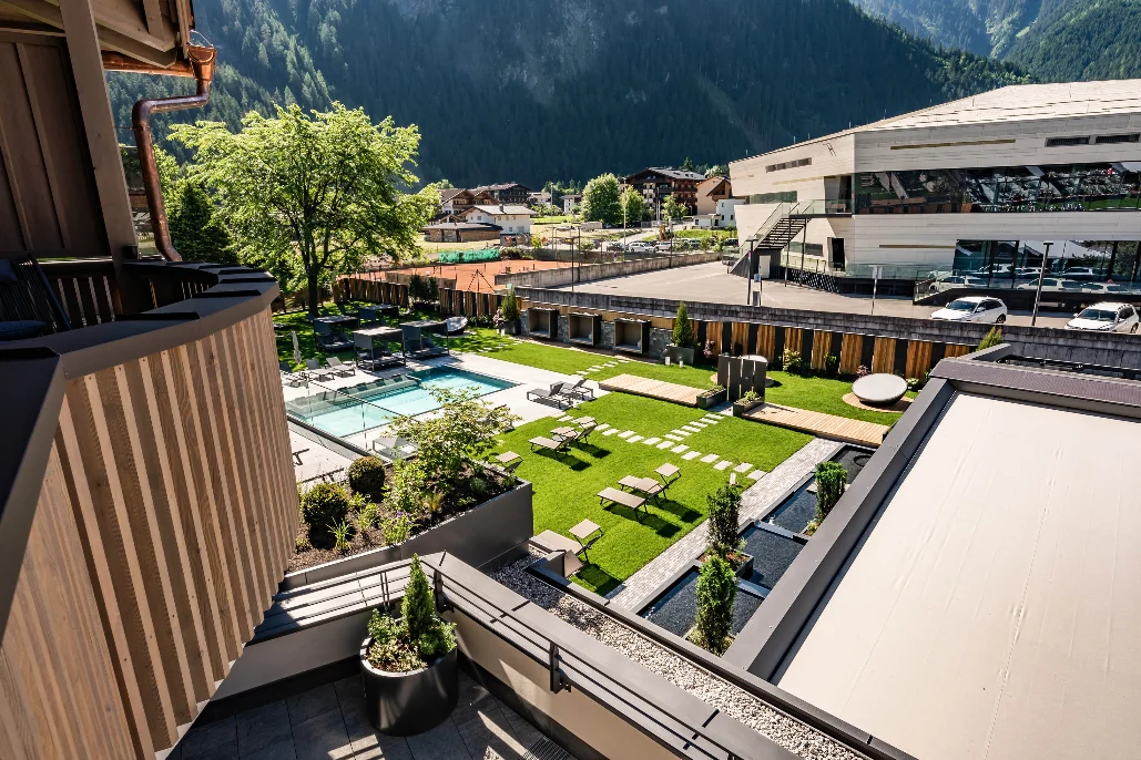 Berghof garden pool with Mayrhofen village view at the four-star Snowbombing hotel.