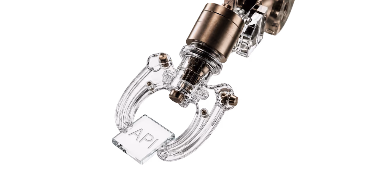 A transparent robotic arm holding a clear glass plaque with the text API on a white background