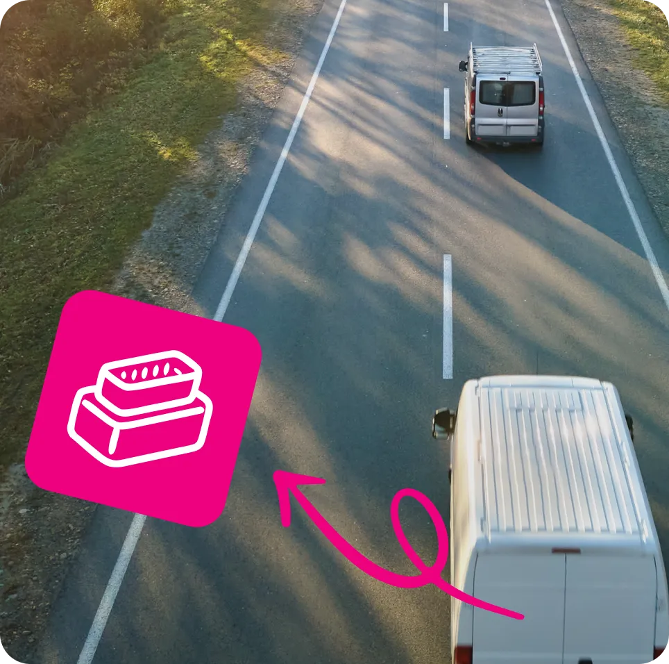 Two white vans driving on a two-lane road with a pink arrow and pink icon showing a vehicle diagnostic connector.