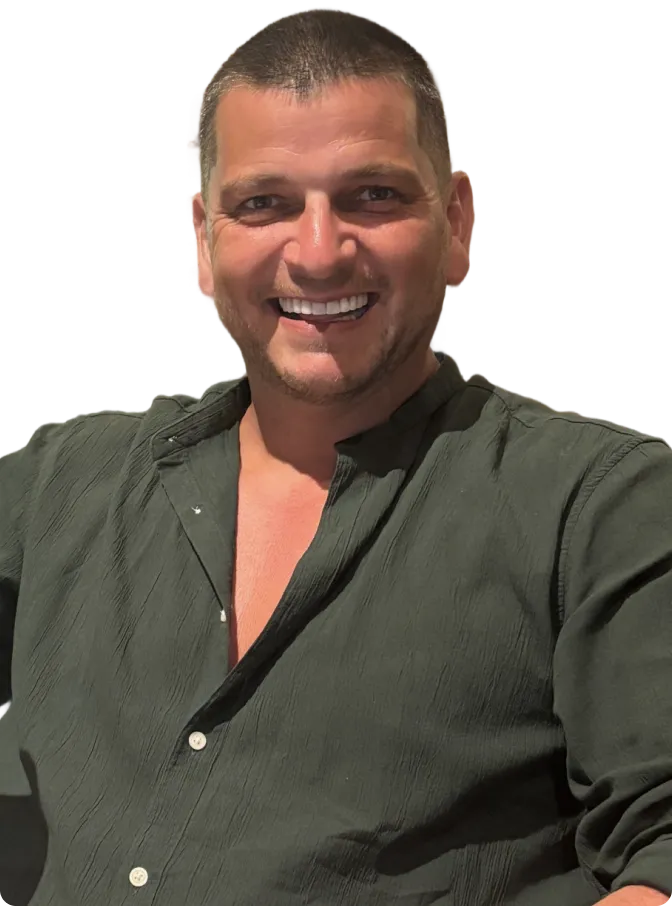 Smiling man with short hair wearing a dark green shirt with the top button open.