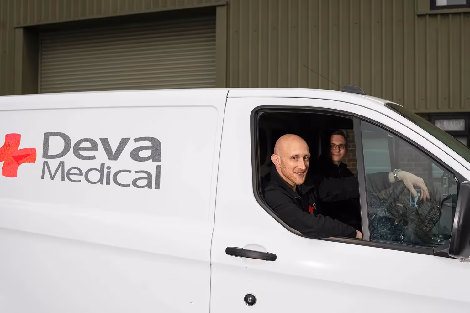 Deva Medical branded van with two staff members inside