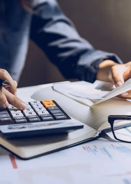Person using calculator for expenses