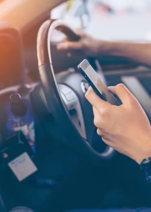 Driver in their vehicle with a phone in hand