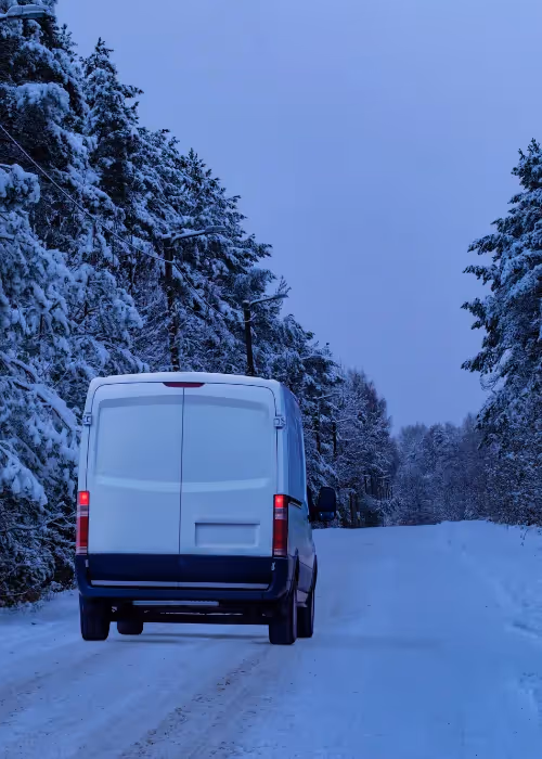 White van driving on a snowy road