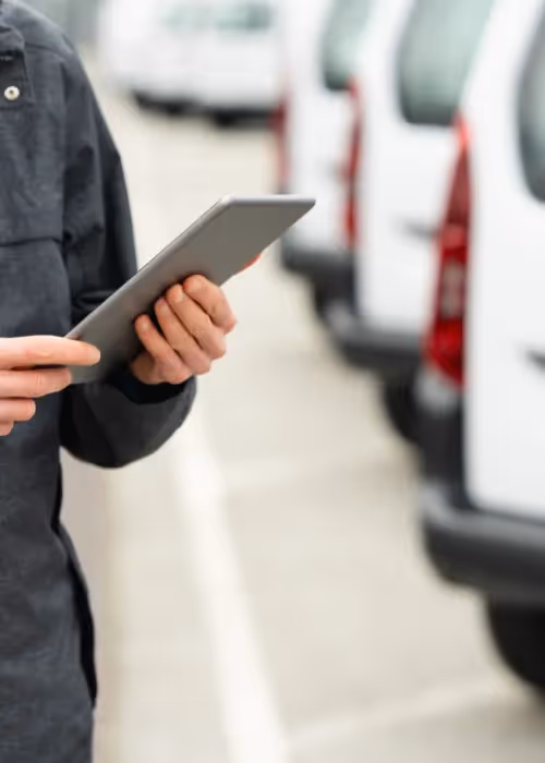man on tablet infront of vans