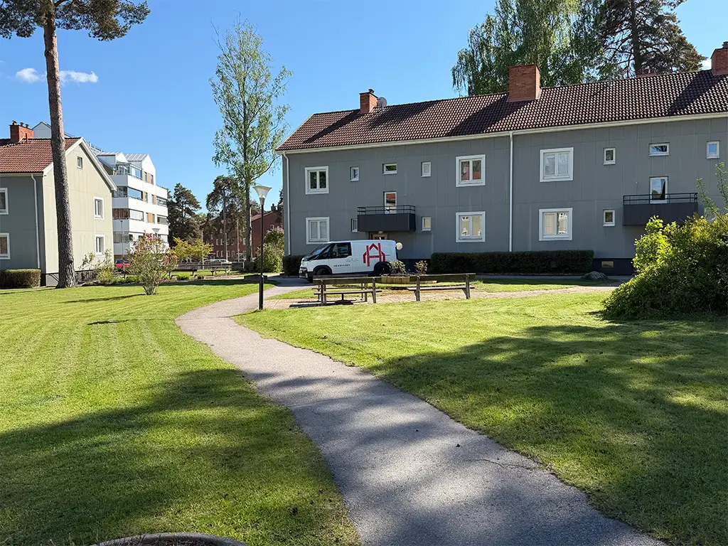 Bild på Hembygdens fastigheter med arbetsbil framför.
