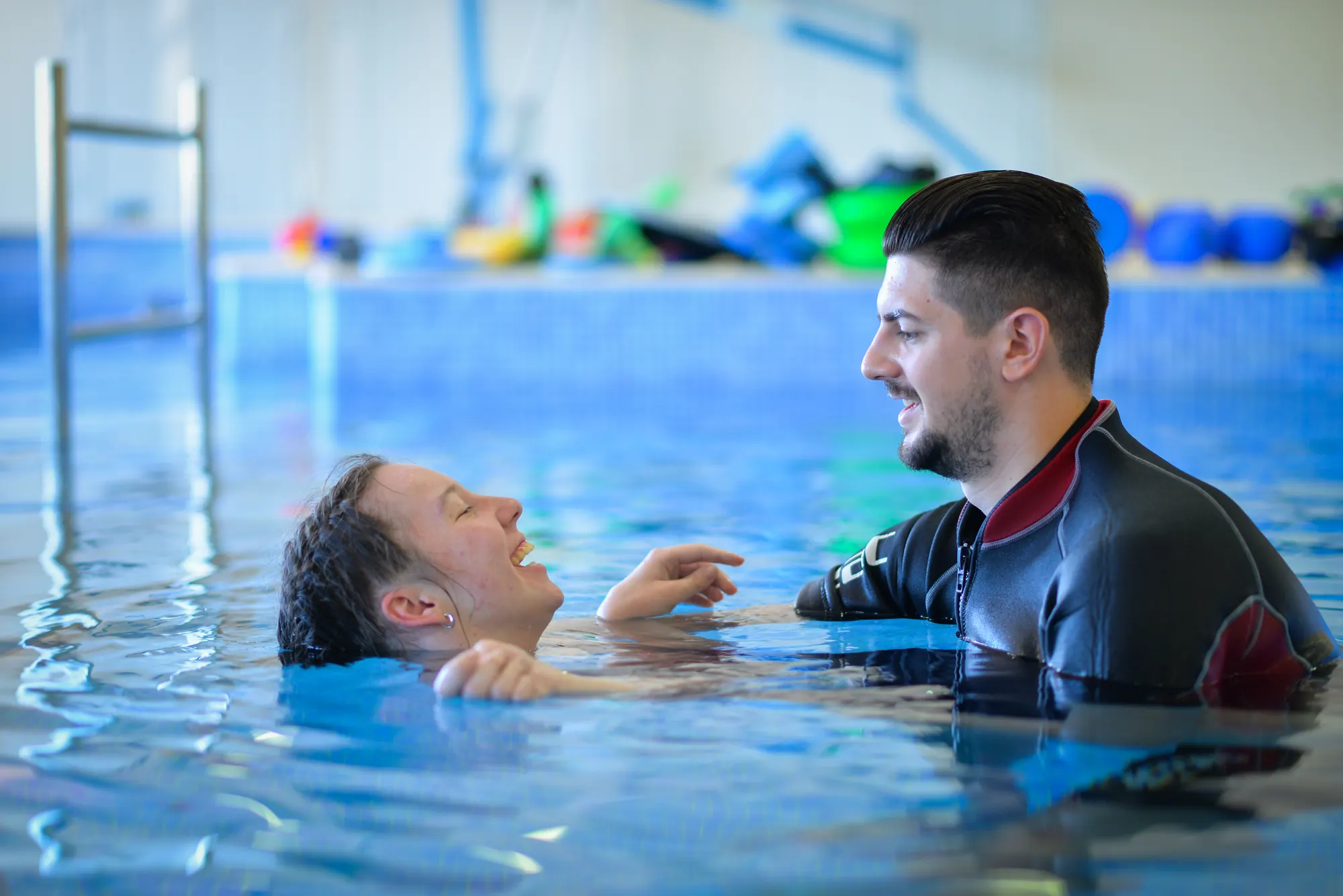 Therapist supporting a patient floating in the hydrotherapy pool