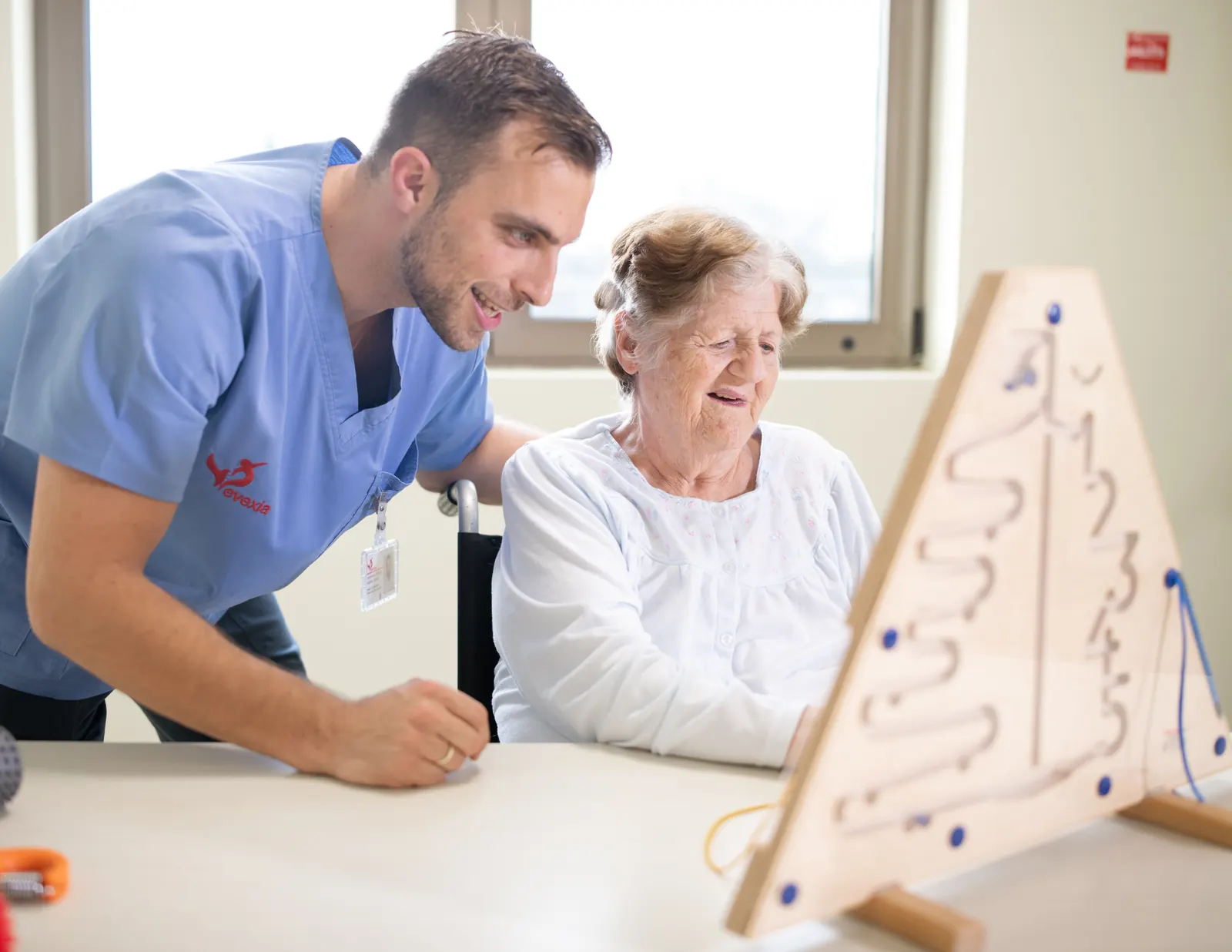 Patient practising hand skills at a table with an occupational therapist