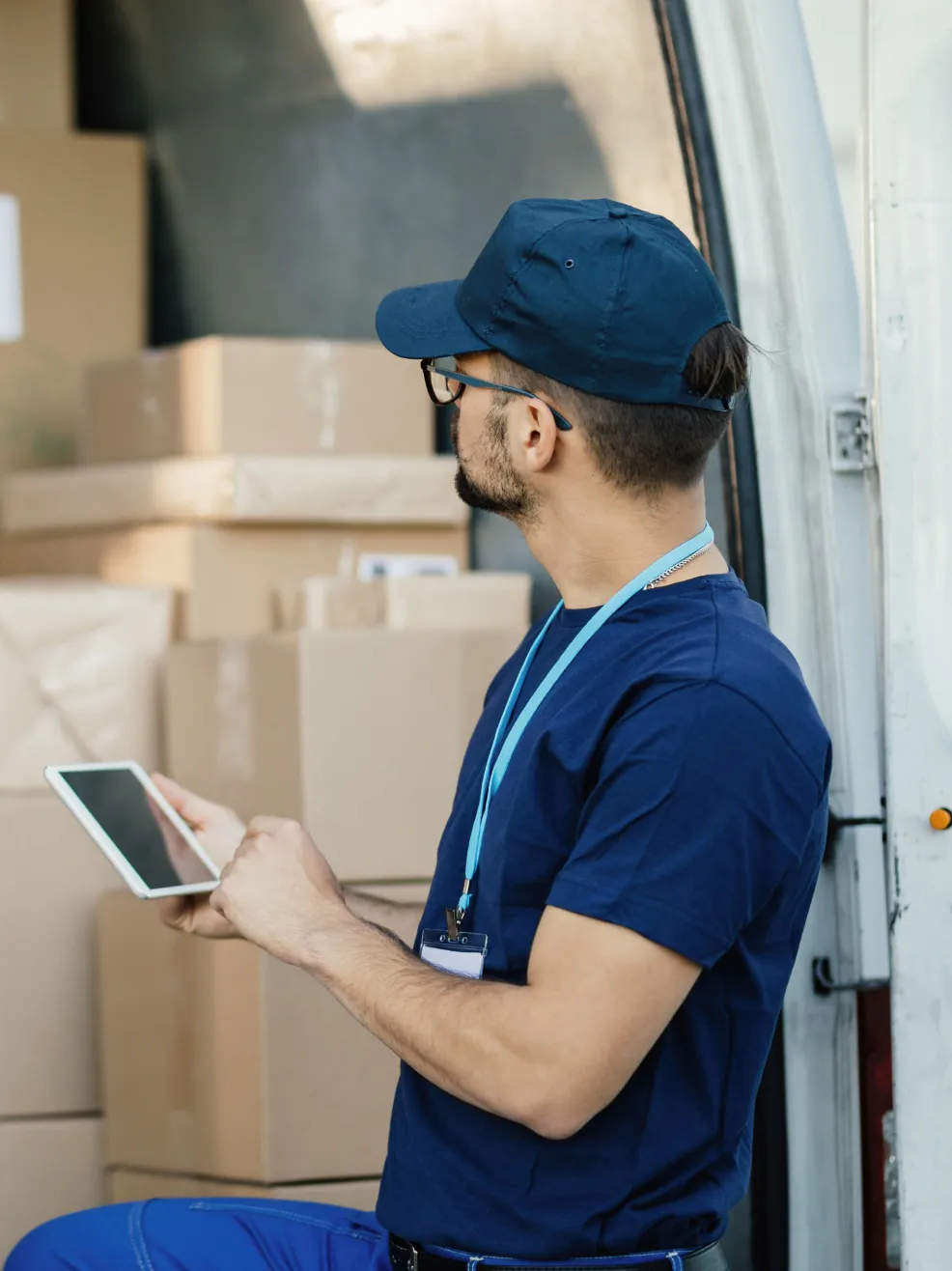 Delivery worker using a phone by boxes