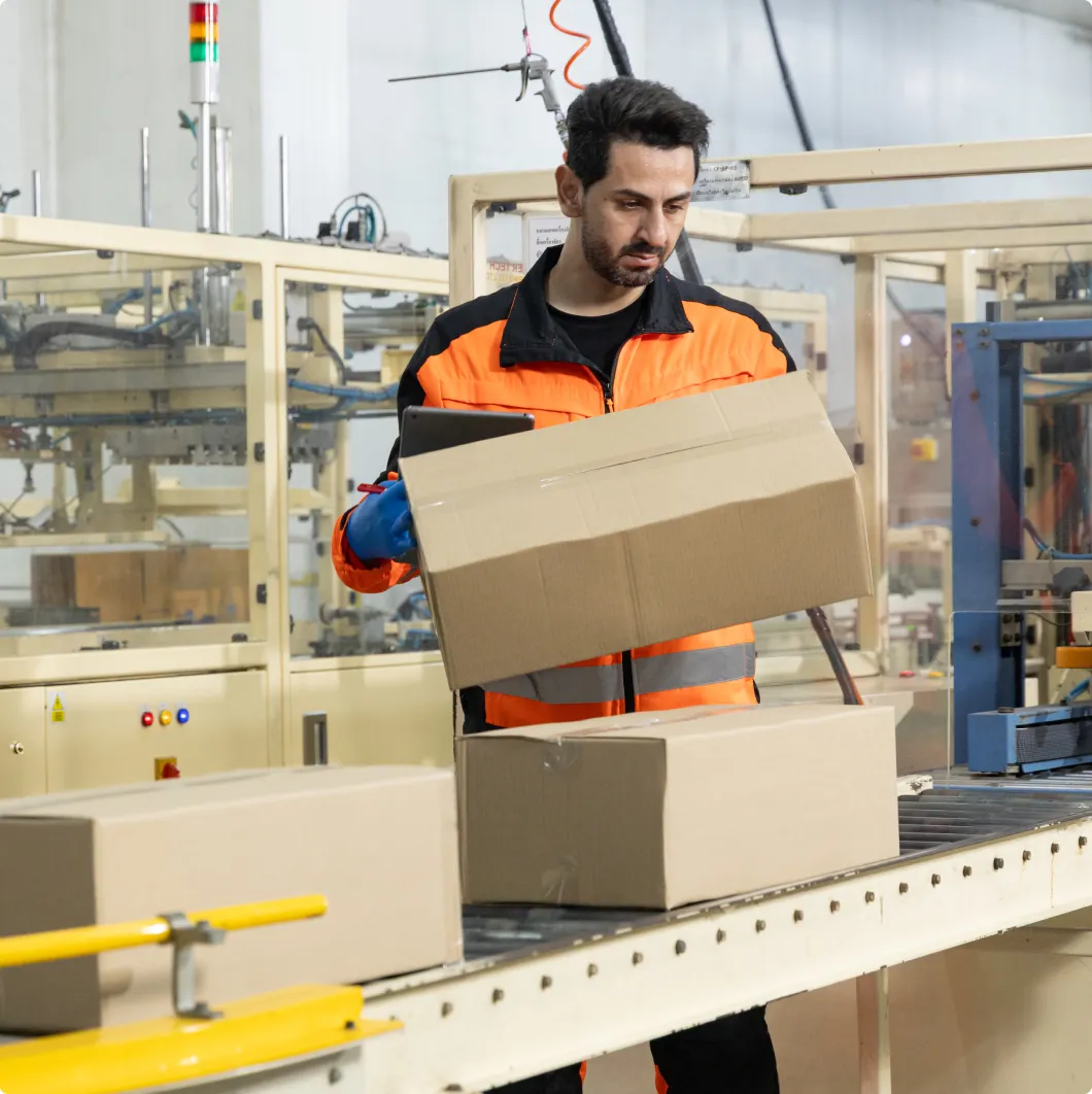 Worker packing boxes on a production line