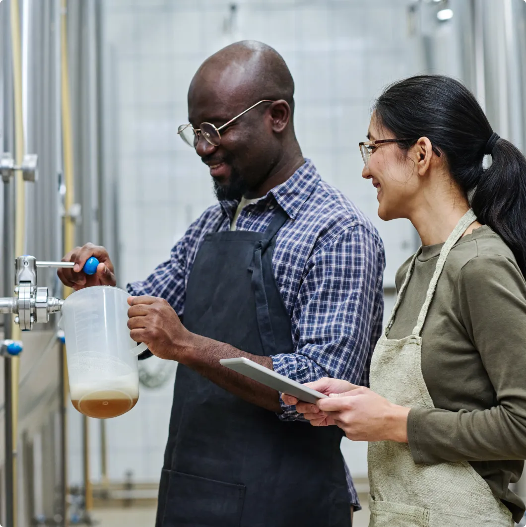 Two workers with a sample in a brewery