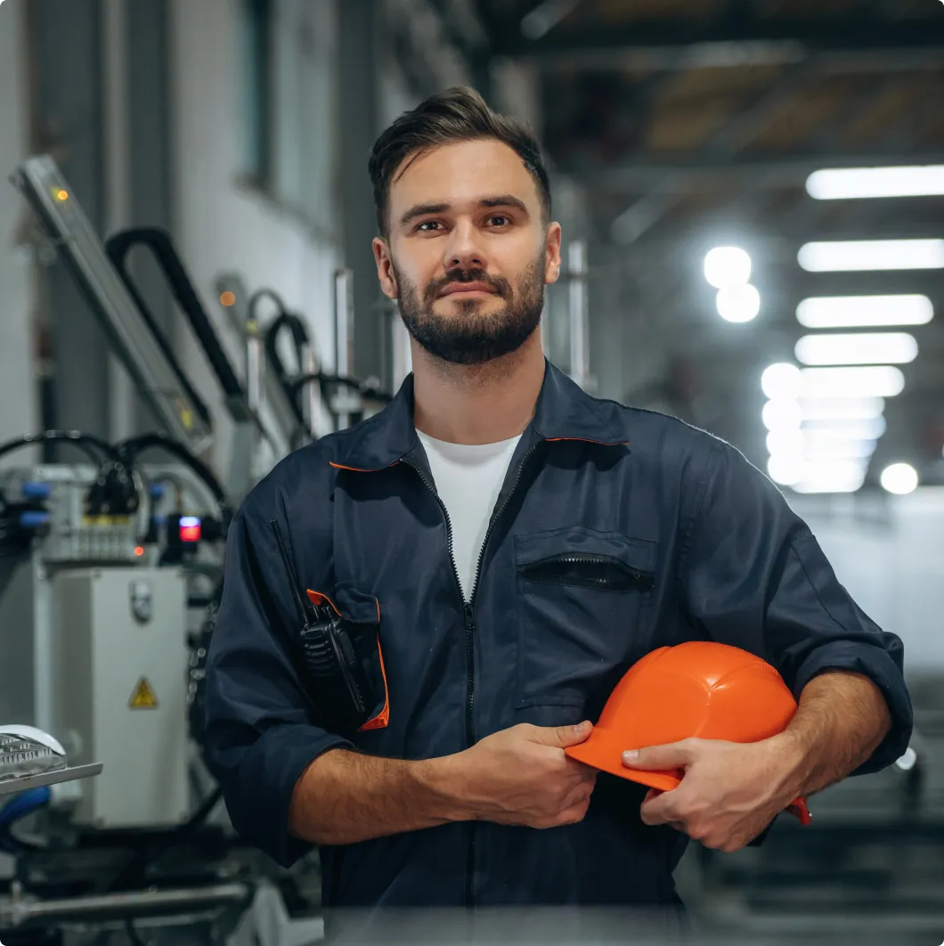 Worker holding a hard hat in a plant