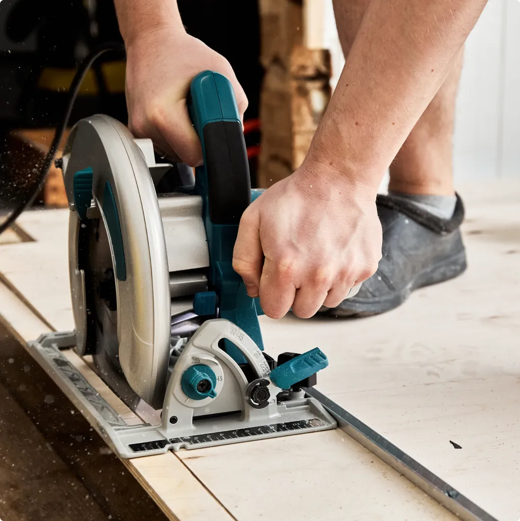 Hands using a circular saw to cut a board
