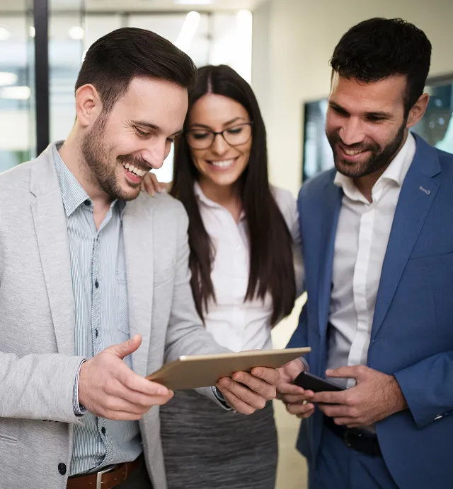 Three colleagues looking at a tablet in a showroom