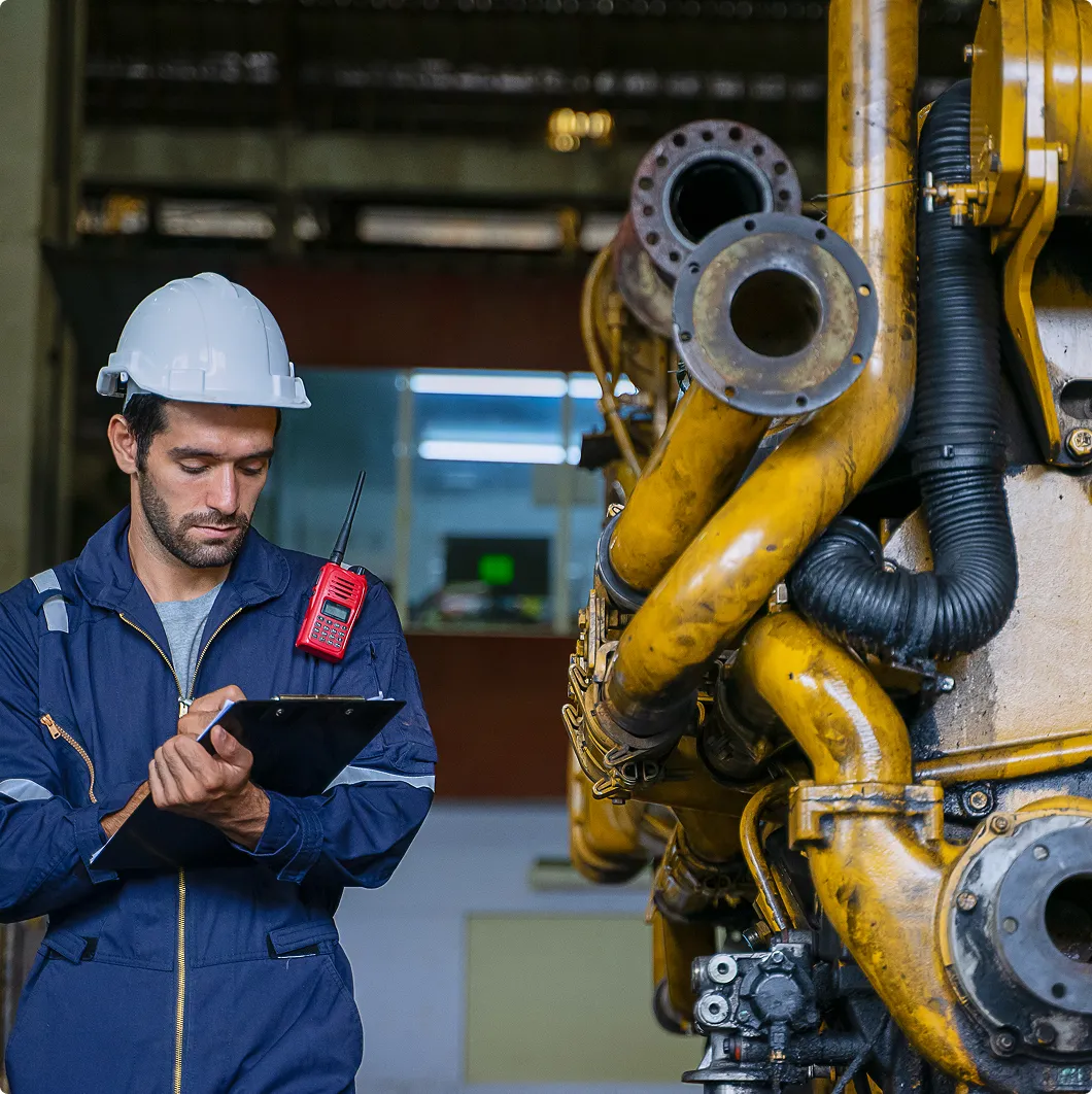 Engineer with a clipboard by machinery