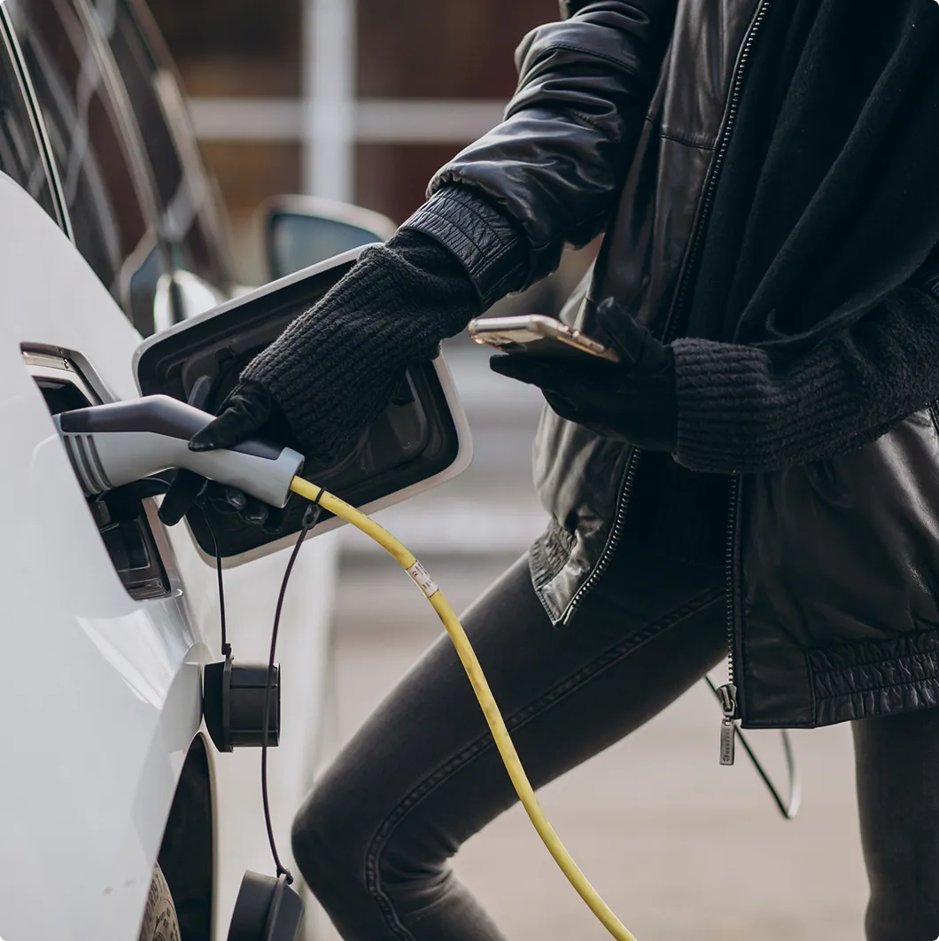Person using a phone while charging an electric car