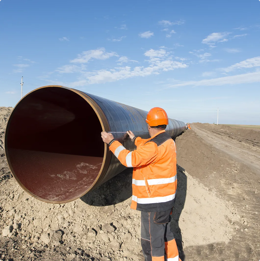 Worker by a large pipeline