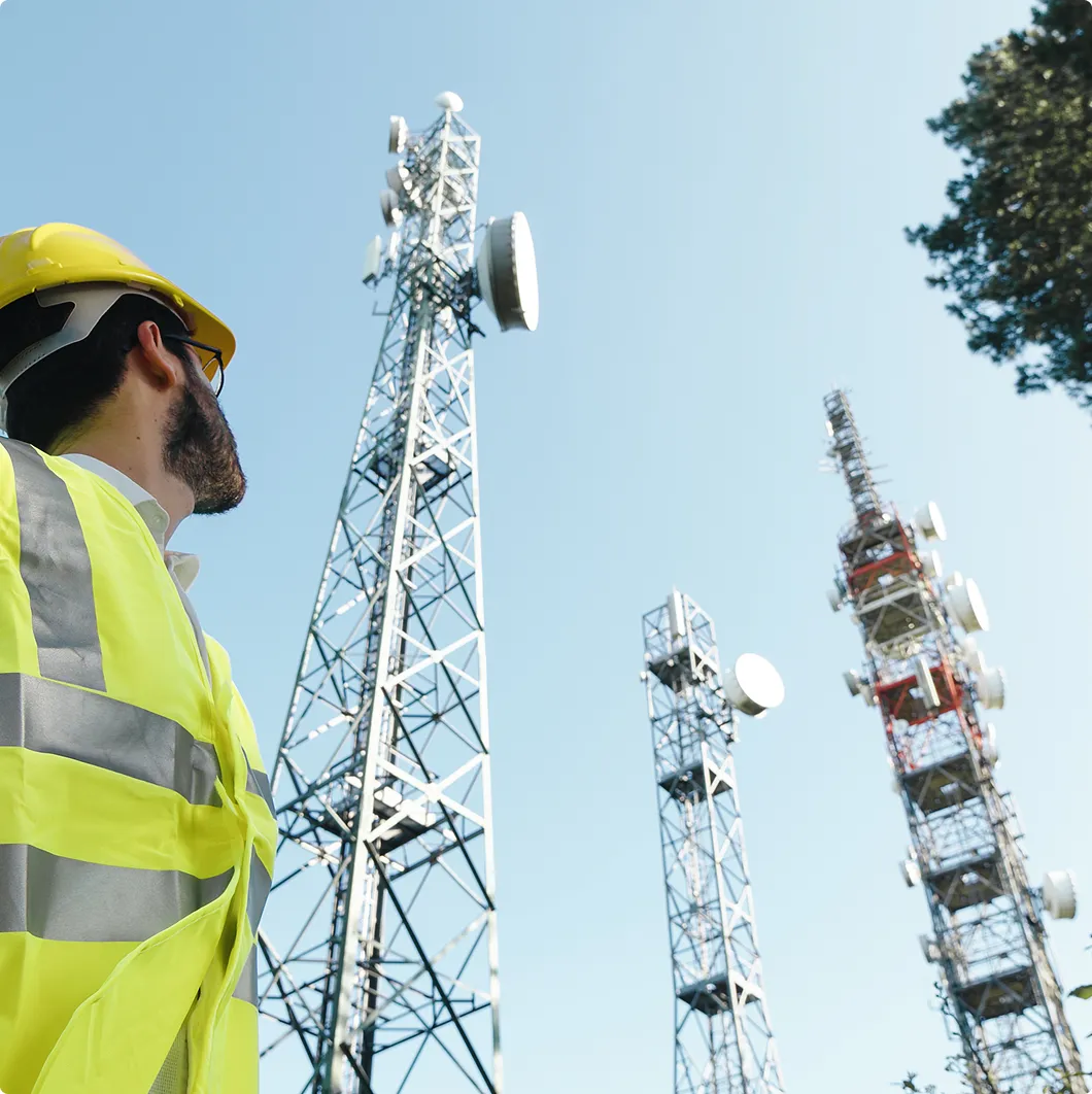 Worker in hi-vis by telecoms masts