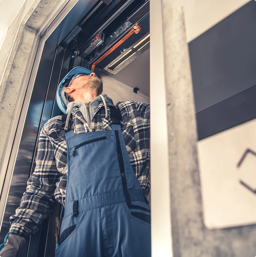 Worker servicing wall-mounted equipment