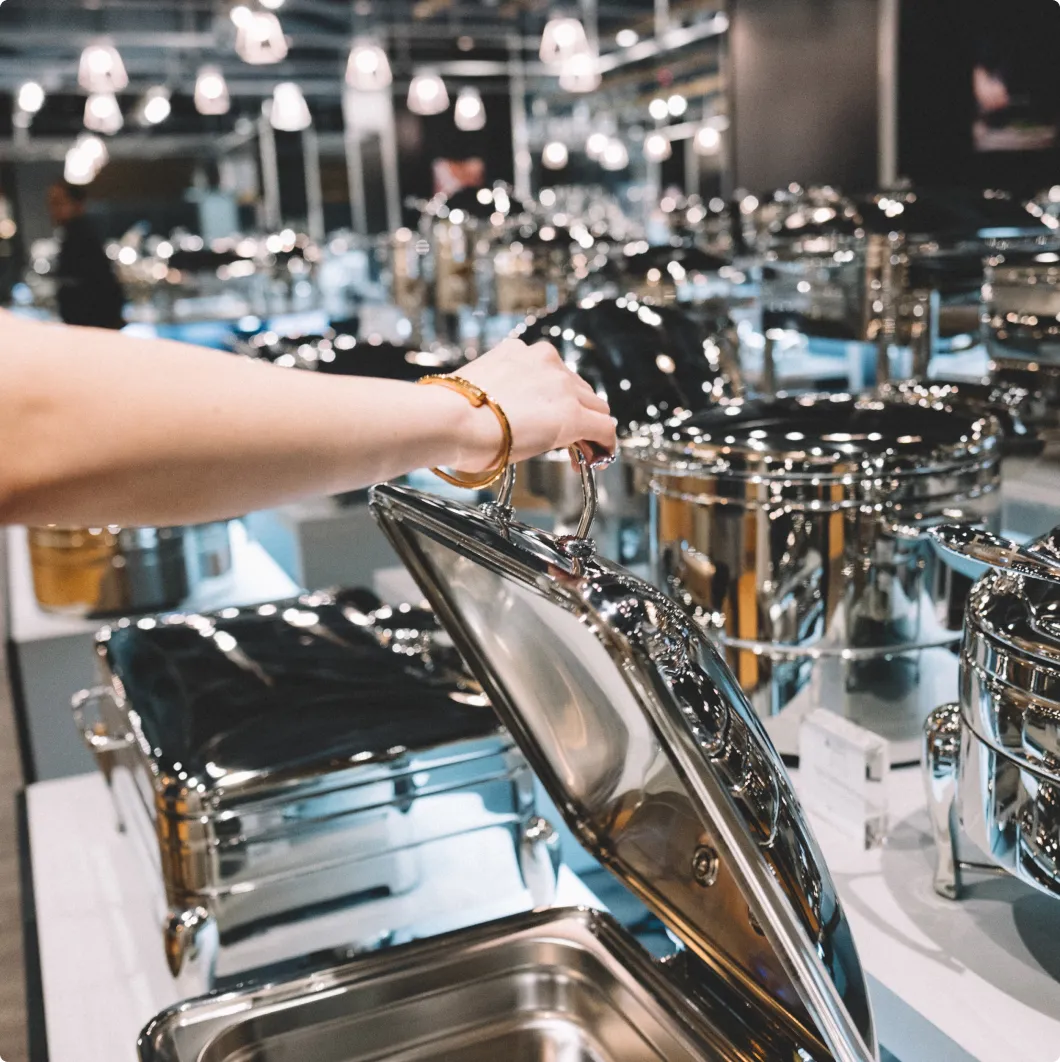 Hands handling stainless steel catering equipment