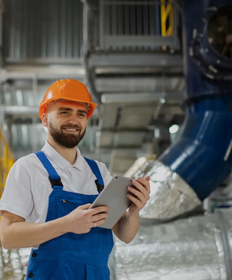 Smiling worker holding a tablet in a plant