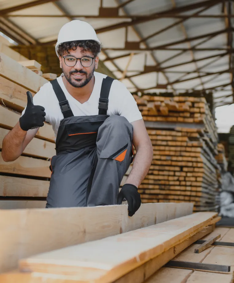Worker carrying timber at a builders' merchant