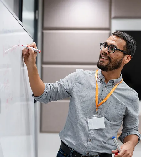 Man writing on a whiteboard in an office