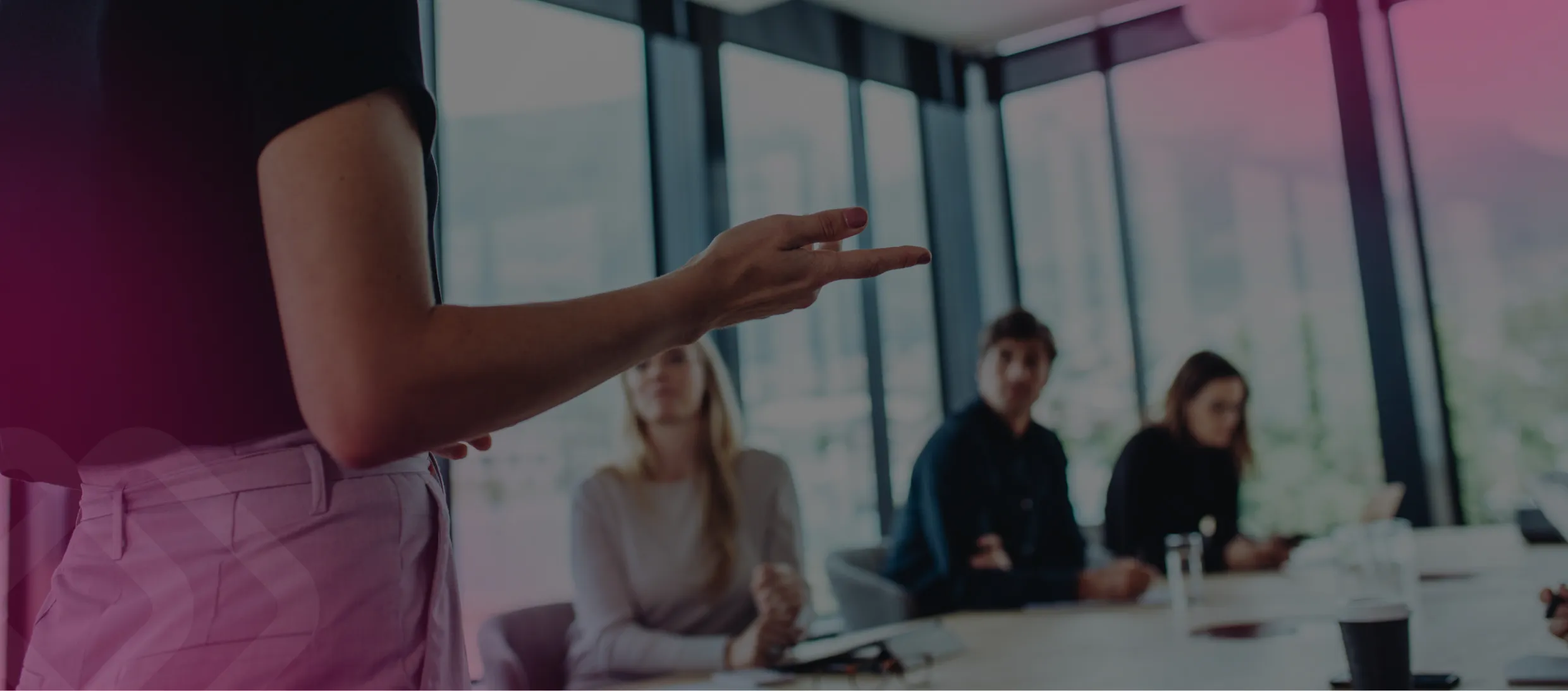 Woman gesturing to colleagues in a meeting