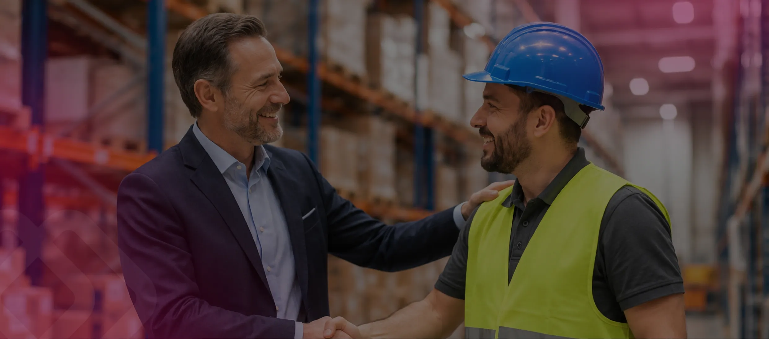 Businessman and worker shaking hands in a warehouse