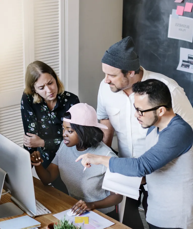 Team collaborating around a computer in an office
