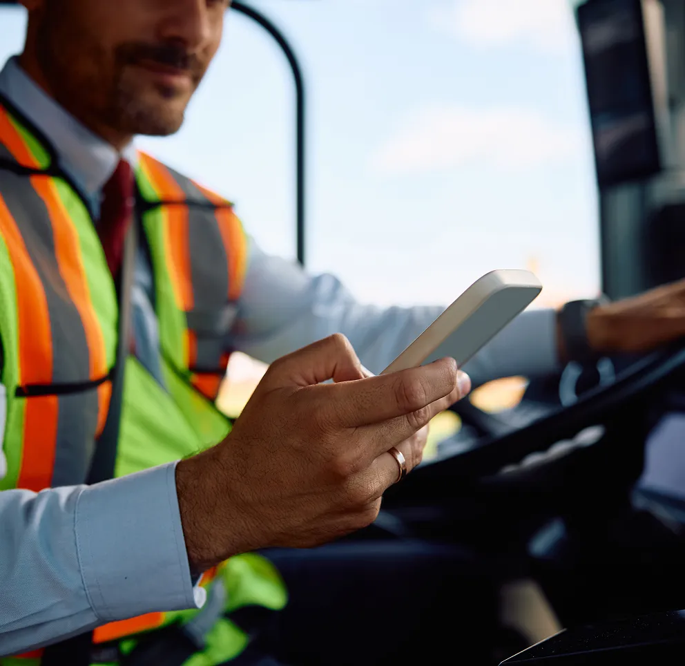 Driver in hi-vis using a tablet in a truck cab