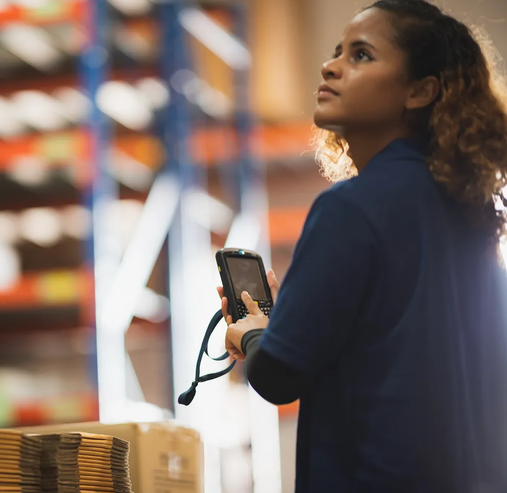 Warehouse worker with a scanner checking high shelves