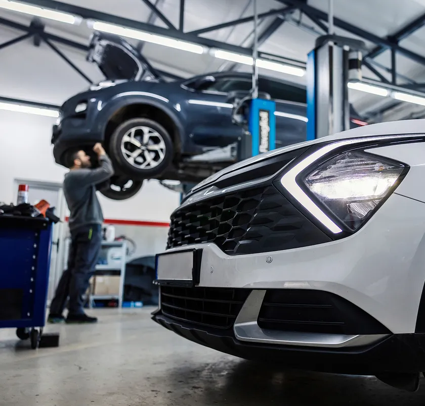 Car raised on a ramp being serviced in a workshop