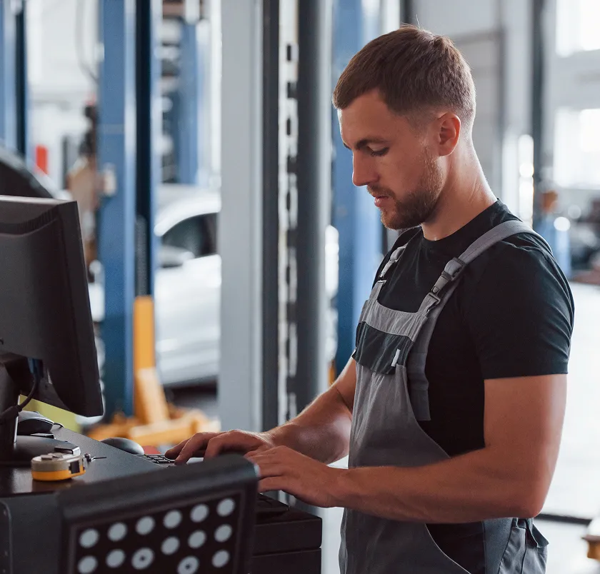 Mechanic using a wheel alignment machine