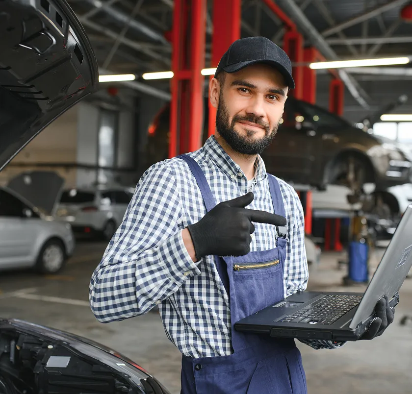 Mechanic giving a thumbs up while holding a laptop