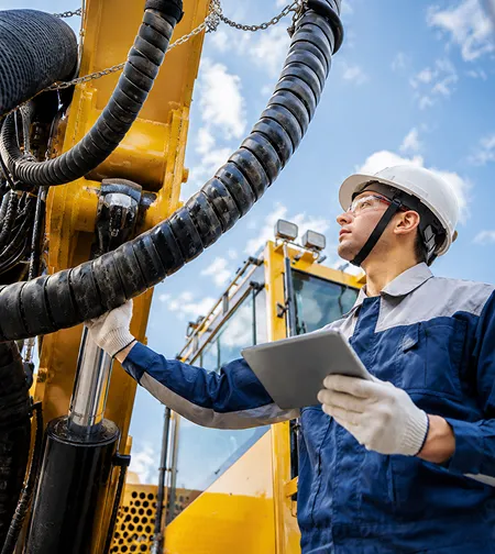 Technician using a tablet to inspect plant machinery